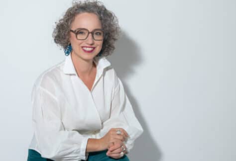 Christine Maria Kaltenleitner sitzt im Sommer in weisser Bluse auf einem Stuhl. Referentin des MC Lago Webinars «Der unterschätzte Erfolgsfaktor: Selbstwertgefühl» am 24. August 2026.