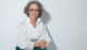 Christine Maria Kaltenleitner sitzt im Sommer in weisser Bluse auf einem Stuhl. Referentin des MC Lago Webinars «Der unterschätzte Erfolgsfaktor: Selbstwertgefühl» am 24. August 2026.
